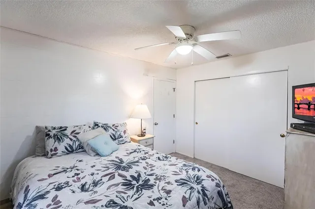 a bedroom with a bed and a ceiling fan