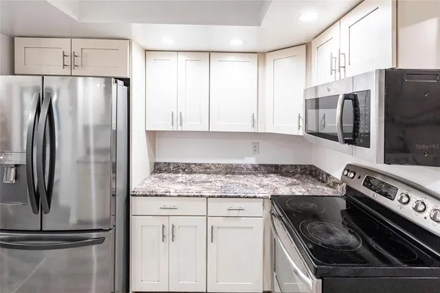 a kitchen with stainless steel appliances granite countertop a refrigerator sink and stove