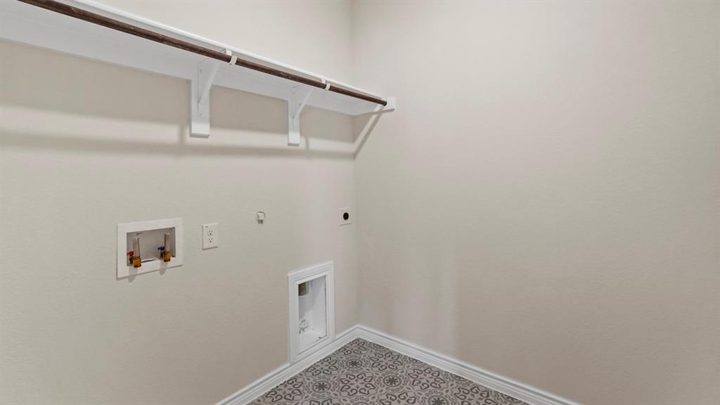 447 Epiphany Lane Lavon, TX 75166 - Photo 10 of 31 Laundry area featuring an overhead shelf with a clothing rod, patterned floor tiling, and neutral wall paint