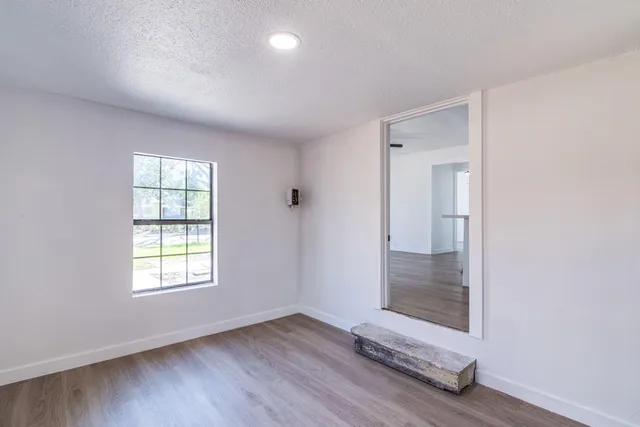 an empty room with wooden floor and closet