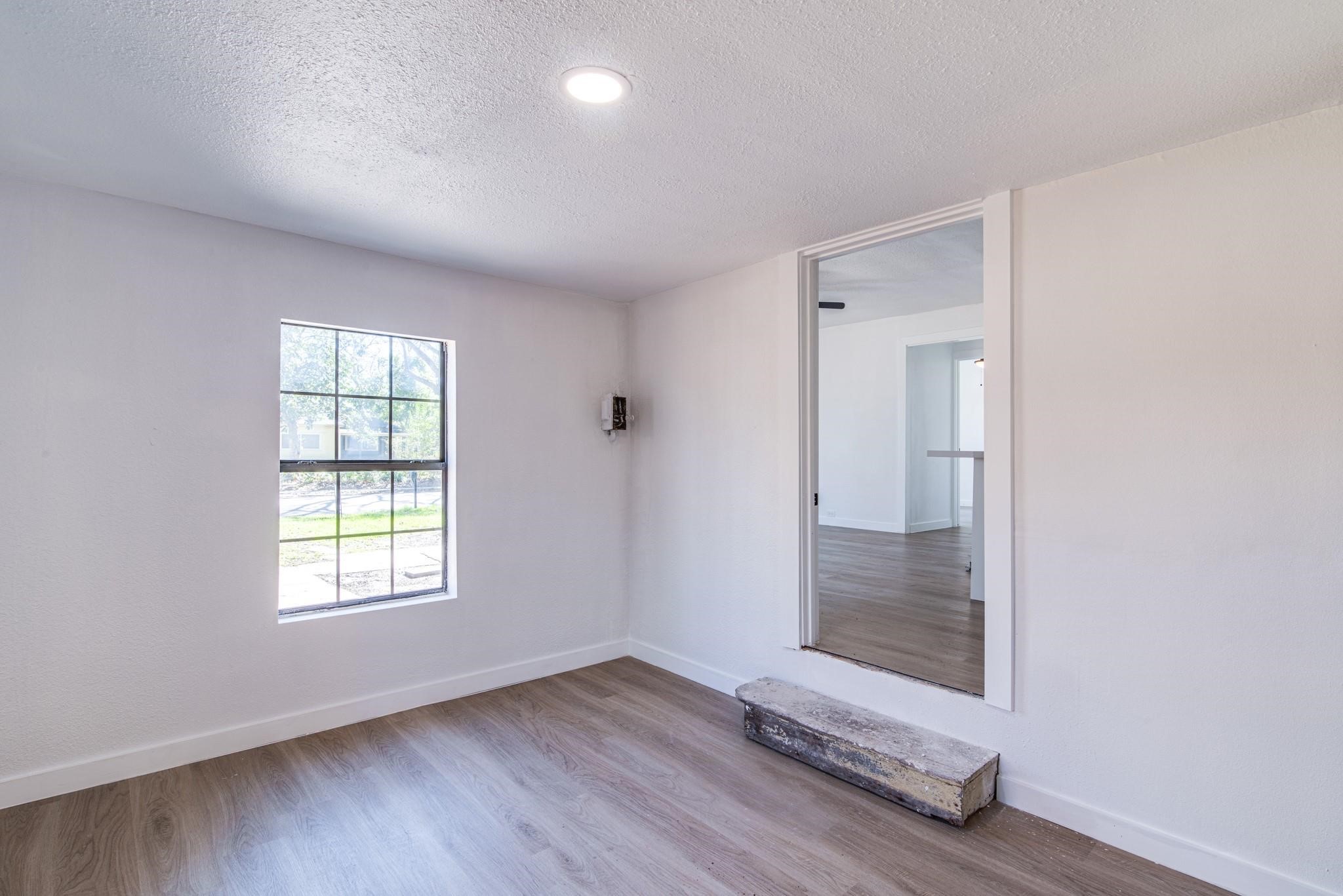 1105 North Valderas Street Angleton, TX 77515 - Photo 5 of 17 an empty room with wooden floor and windows
