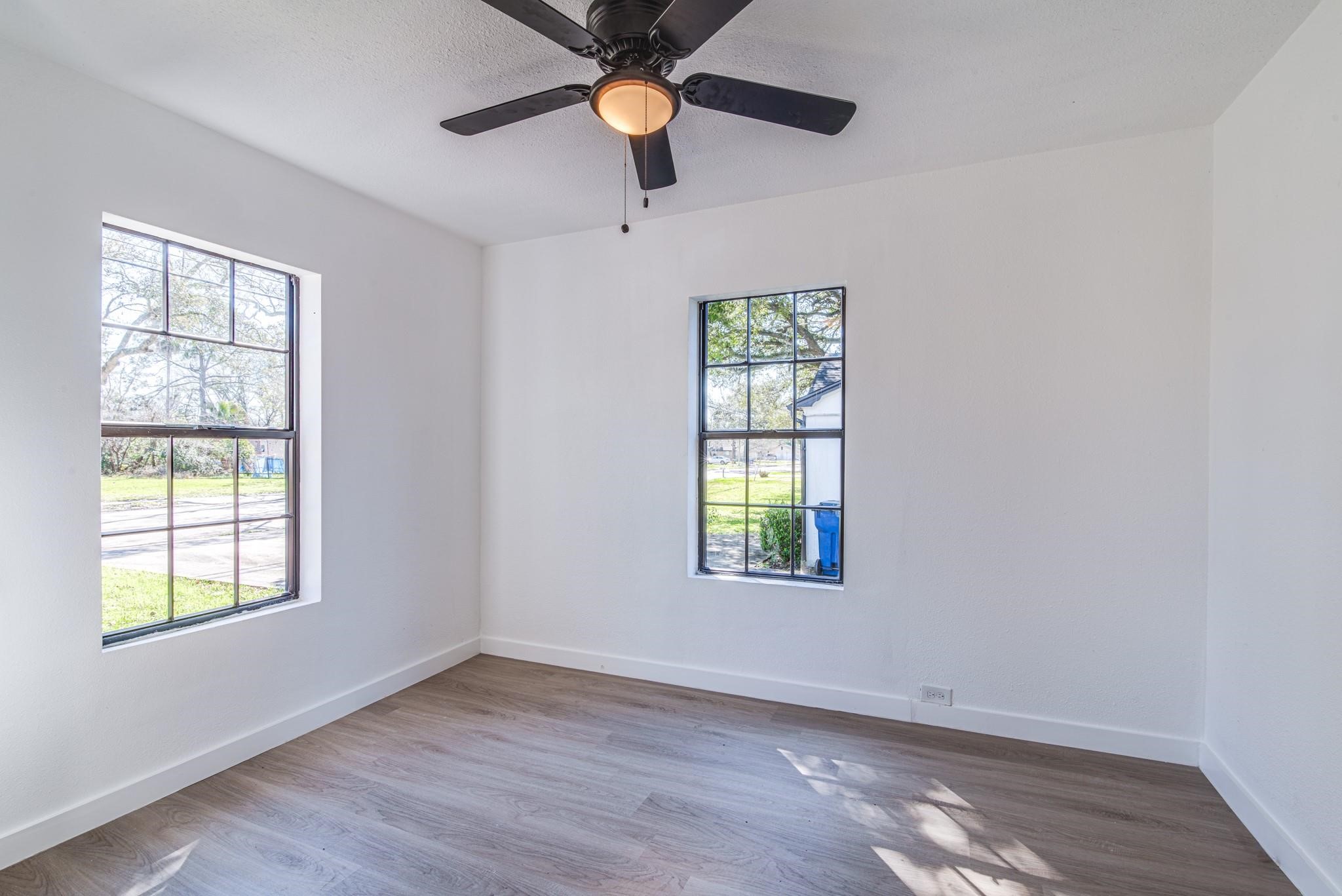1105 North Valderas Street Angleton, TX 77515 - Photo 10 of 17 an empty room with windows and chandelier fan