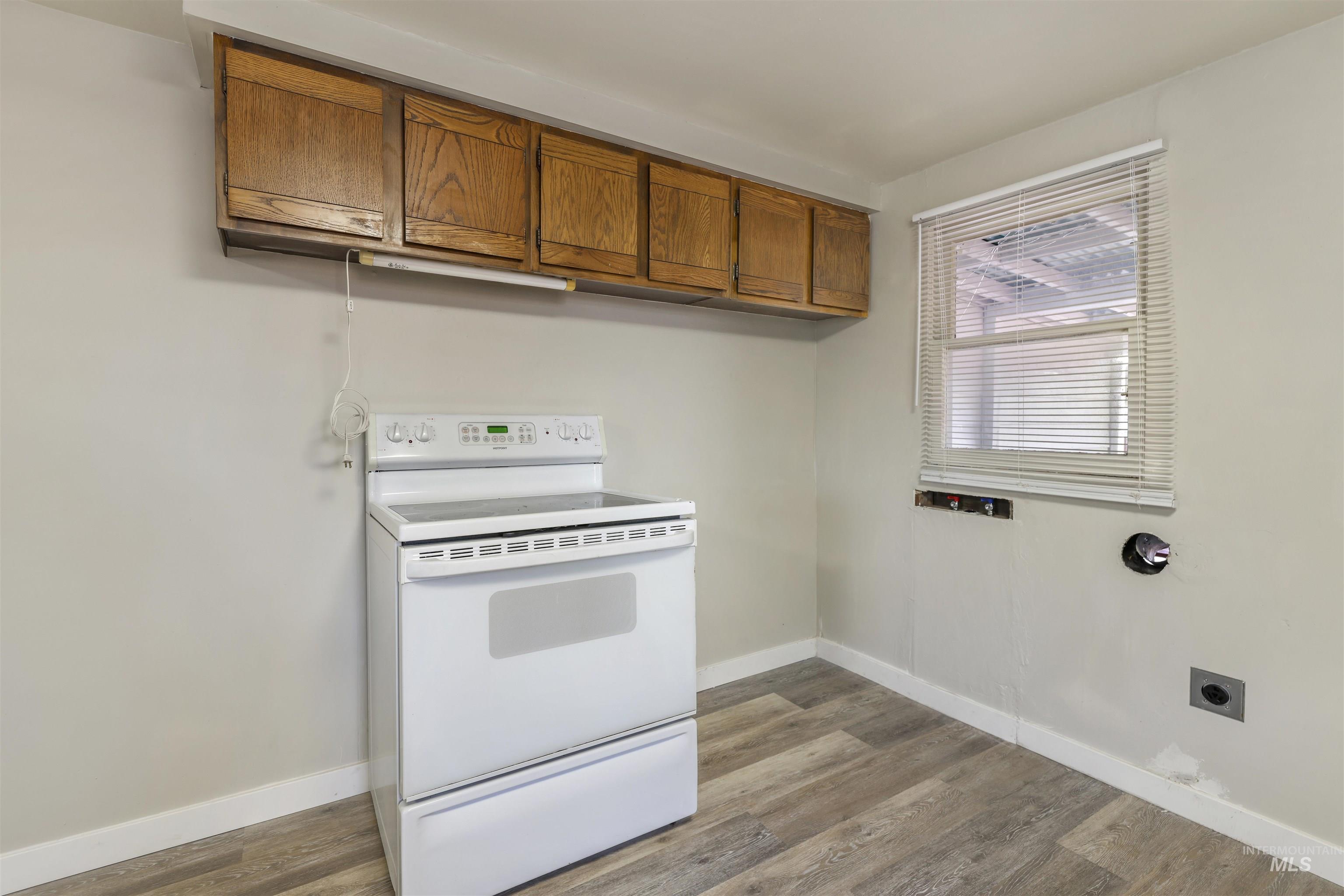 545 Madison Street Twin Falls, ID 83301 - Photo 7 of 23 Kitchen featuring electric range, brown cabinets, and light wood-style flooring