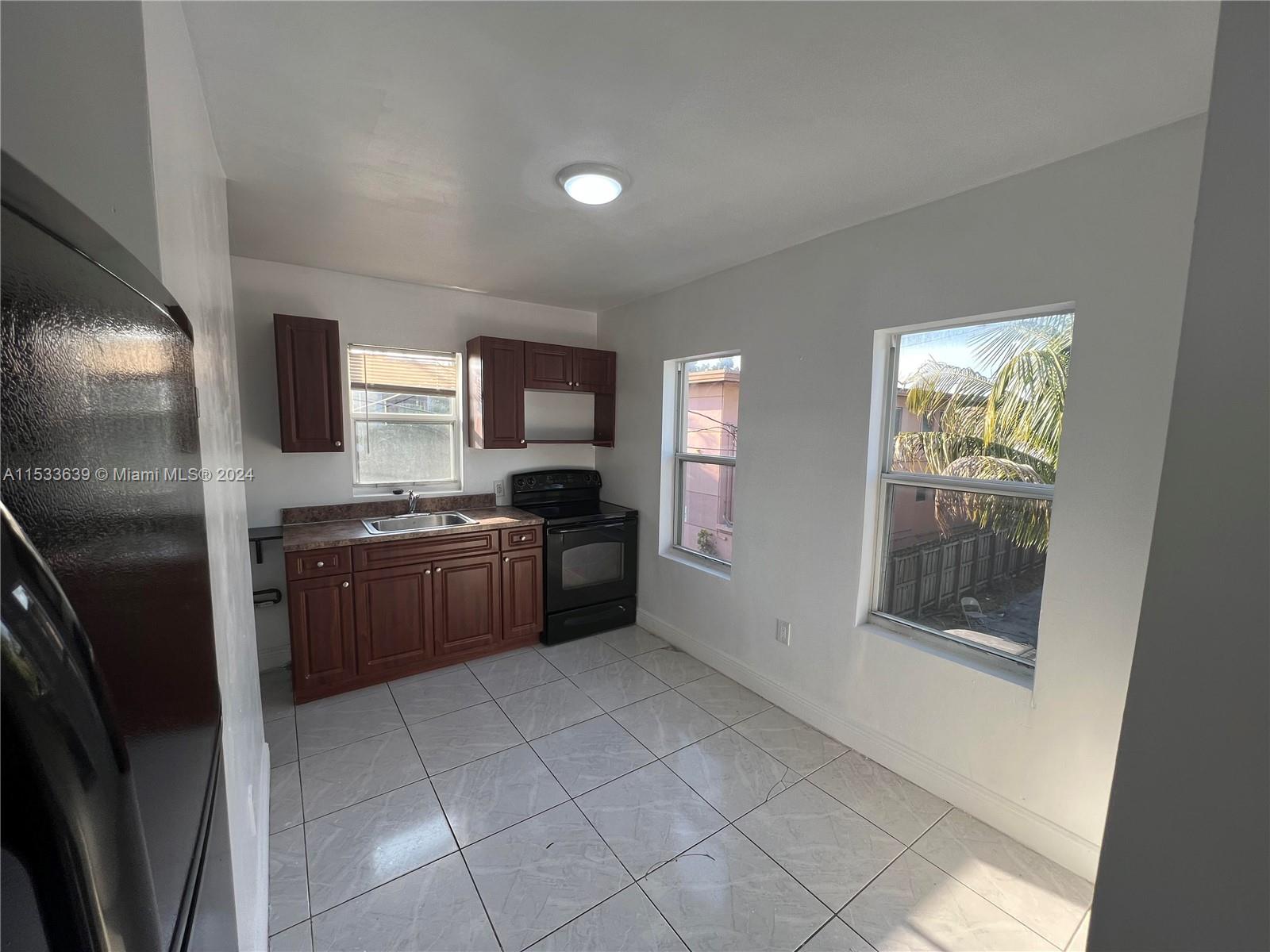 1935 Southwest 2nd Street, Unit 2 Miami, FL 33135 - Photo 3 of 12 a large kitchen with a stove a refrigerator and a sink