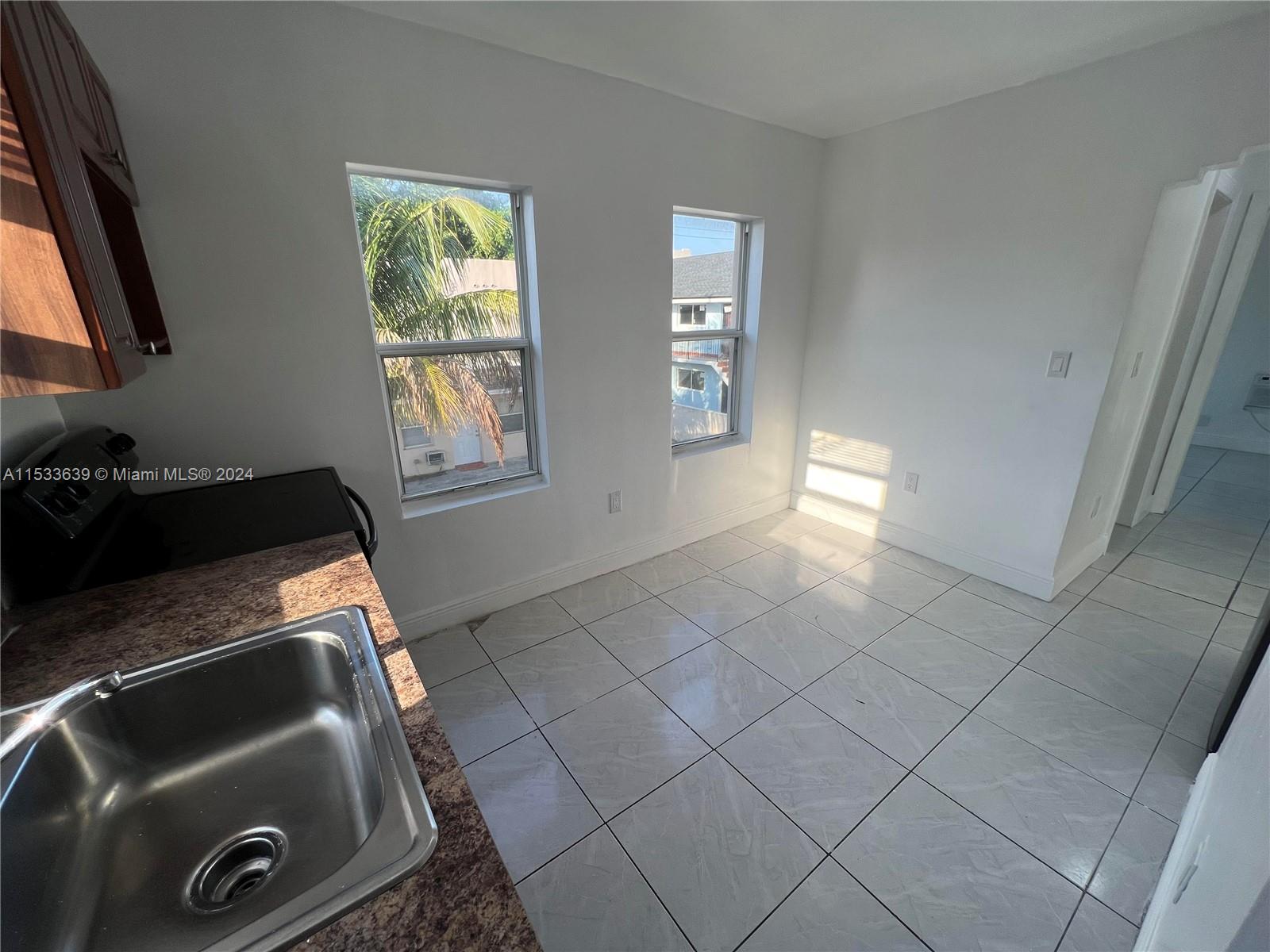 1935 Southwest 2nd Street, Unit 2 Miami, FL 33135 - Photo 4 of 12 a kitchen with a sink cabinets and a window