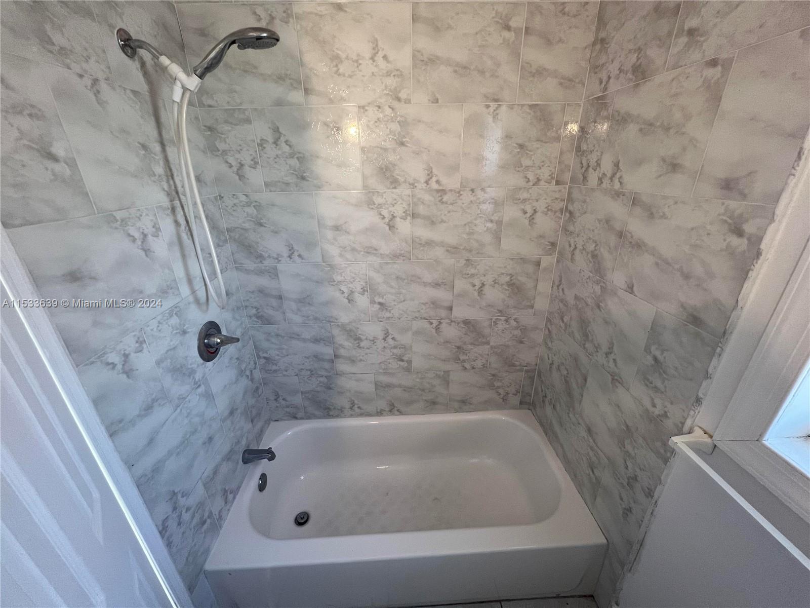 1935 Southwest 2nd Street, Unit 2 Miami, FL 33135 - Photo 6 of 12 a bathroom with a white bath tub and a shower