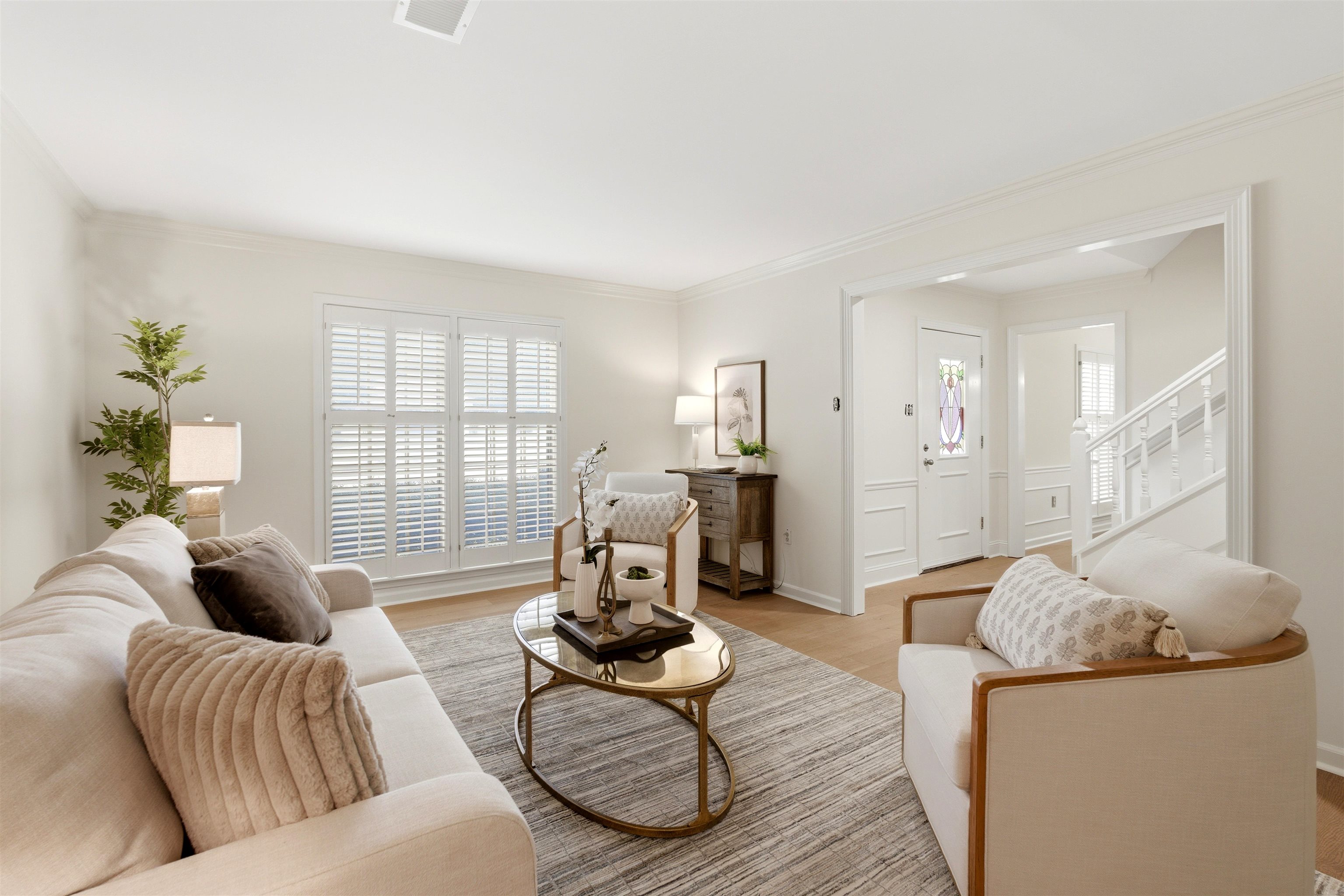 1984 Allenby Road Germantown, TN 38139 - Photo 23 of 37 Living area featuring wood-finish flooring, white plantation shutters, crown molding, and a visible entryway with a white paneled door