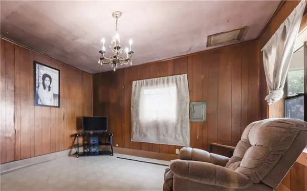 a living room with furniture a chandelier and a window