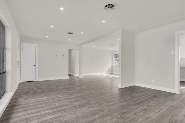 a view of an empty room with wooden floor