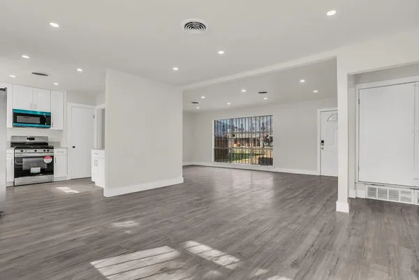 a view of an empty room with a kitchen