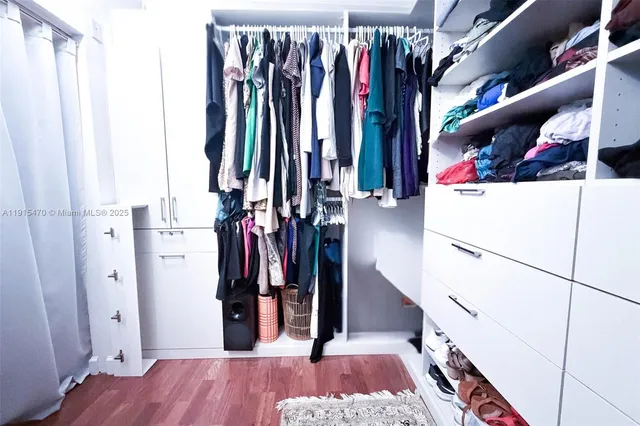 a view of walk in closet with clothes and shoes