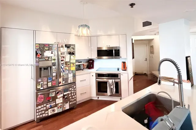 a kitchen with stainless steel appliances kitchen island granite countertop a refrigerator and a stove top oven