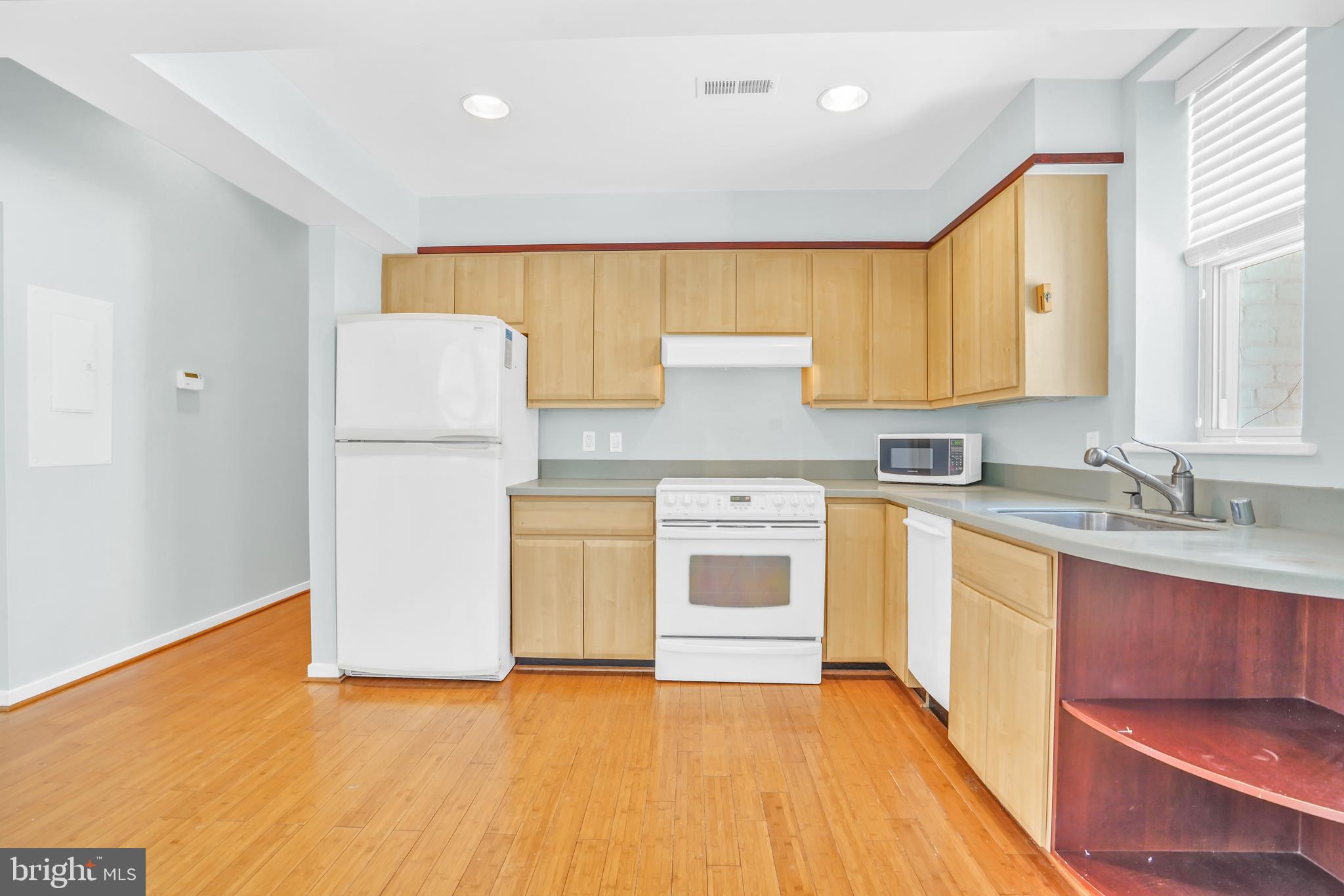2114 N Street Northwest, Unit 46 Washington, DC 20037 - Photo 8 of 26 a kitchen with a sink a stove and a refrigerator