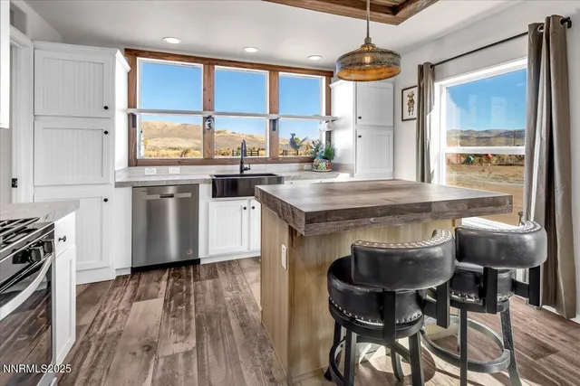 a kitchen with stainless steel appliances granite countertop a stove and a wooden floors