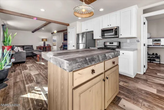 a kitchen with stainless steel appliances granite countertop a sink dishwasher stove and microwave with wooden floor