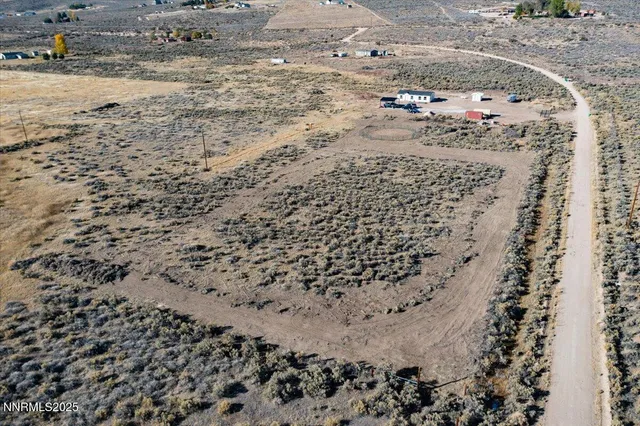 a view of a dry yard with wooden fence