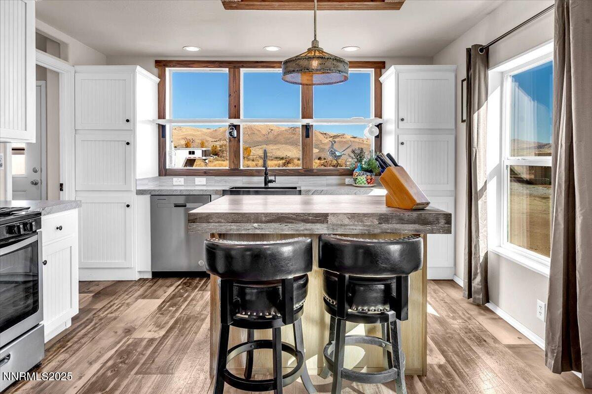 195 Muletail Circle Reno, NV 89508 - Photo 9 of 44 a kitchen with stainless steel appliances wooden floor dining table and chairs
