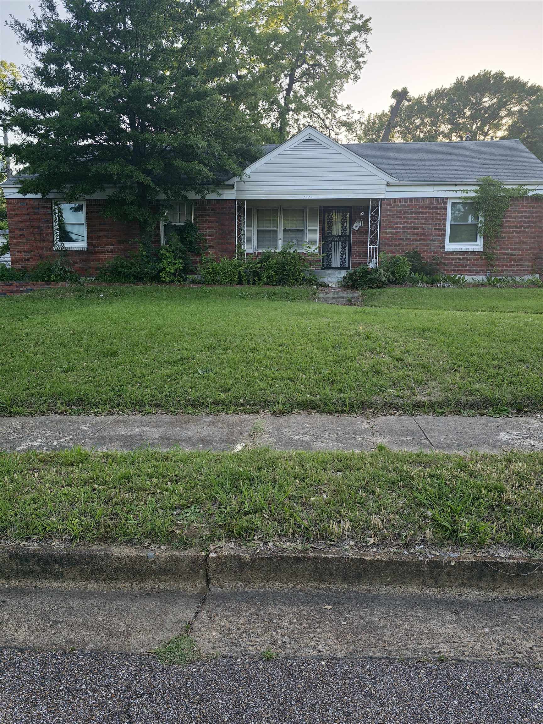1515 Semmes Street Memphis, TN 38114 - Photo 1 of 9 Brick ranch-style residence featuring a prominent front gable, covered porch, and mature front yard landscaping
