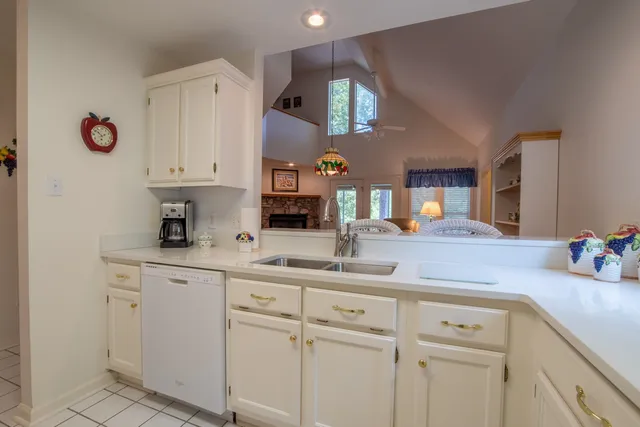 a kitchen with white cabinets and sink