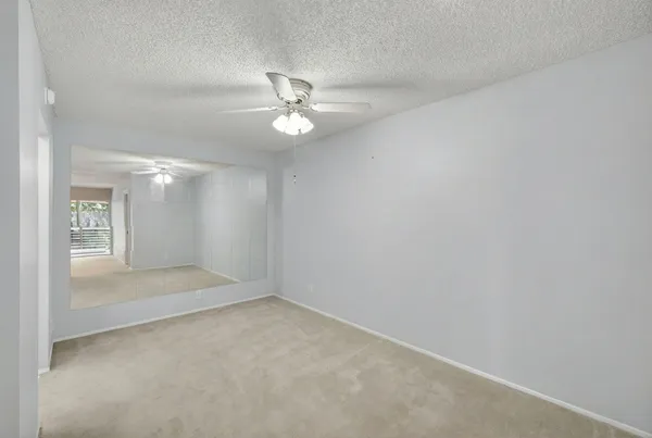 en empty room with windows and ceiling fan