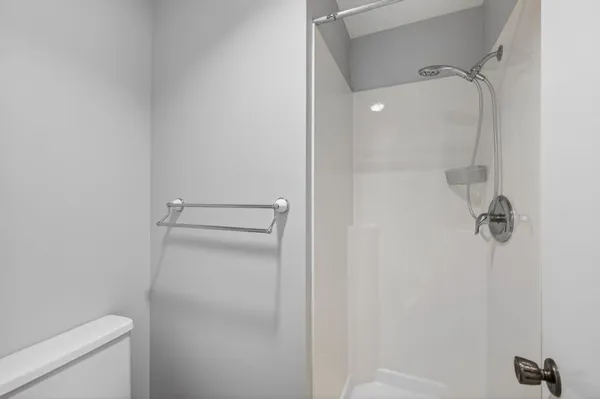 a bathroom with a granite countertop toilet and a shower