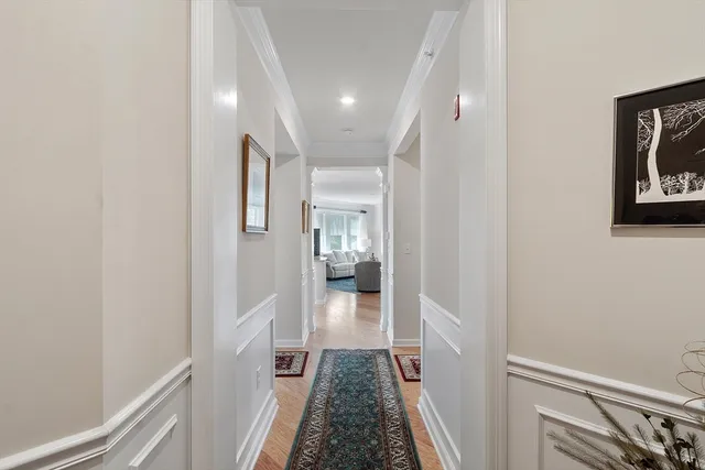 a view of a hallway with wooden floor and staircase