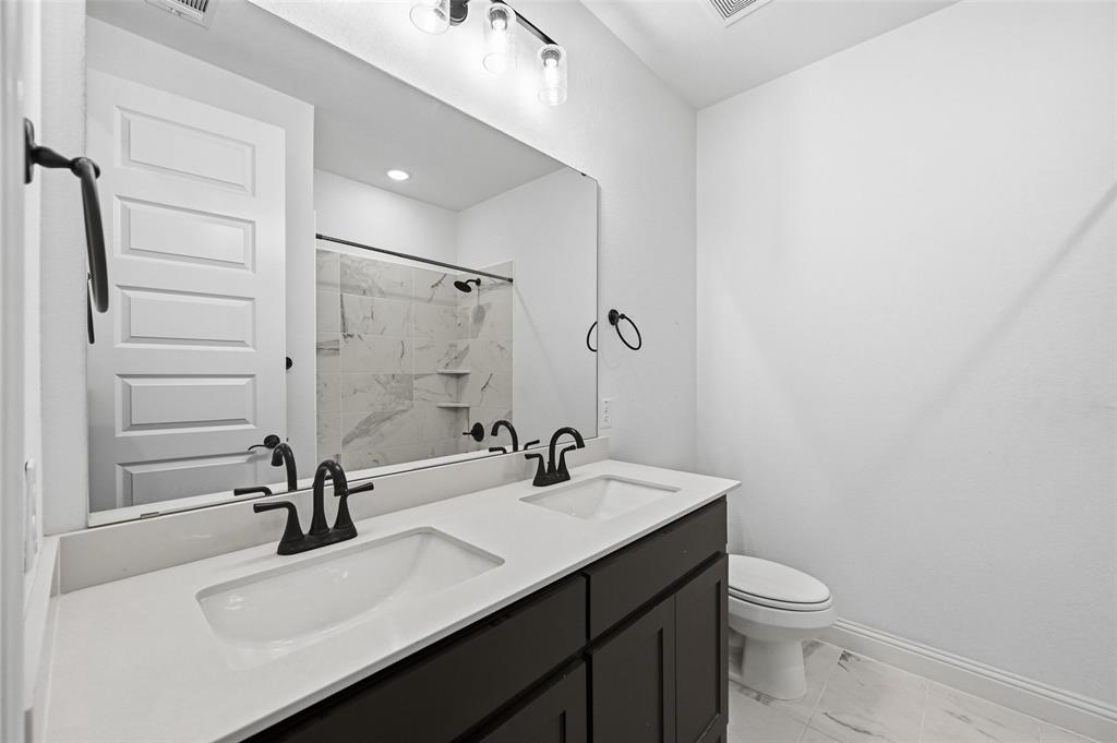 513 Fieldstone Lane Haslet, TX 76052 - Photo 11 of 18 a bathroom with a sink a toilet and a mirror