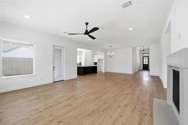 an empty room with a ceiling fan and window