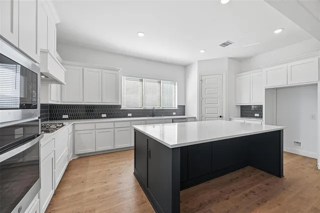 a kitchen with a refrigerator a sink a stove a microwave and cabinets