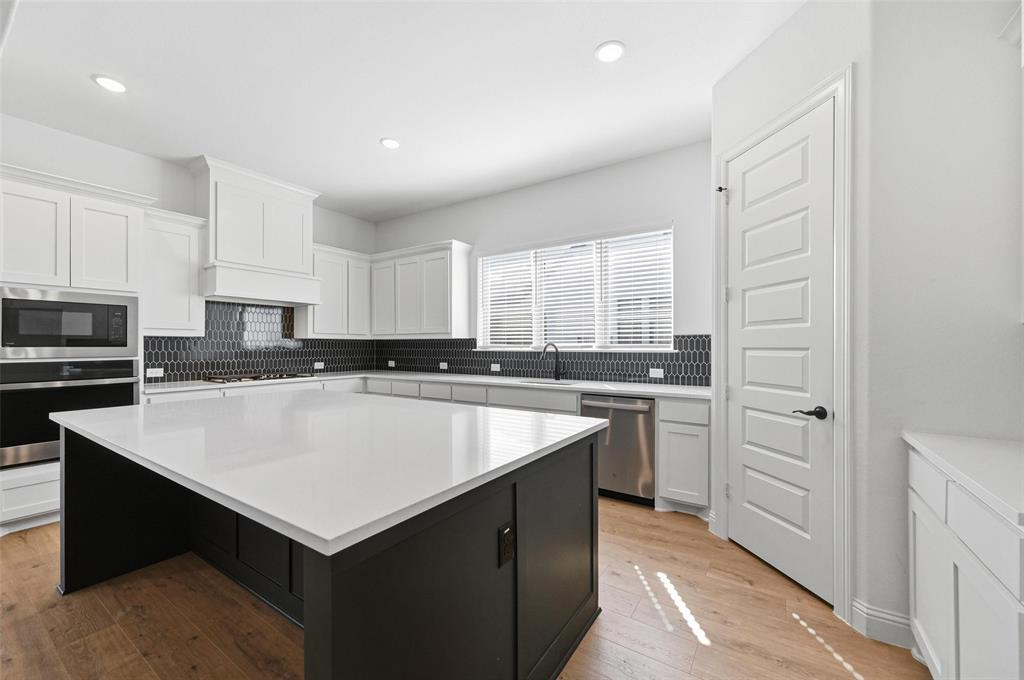 513 Fieldstone Lane Haslet, TX 76052 - Photo 4 of 18 a kitchen with a refrigerator a sink a stove a microwave and cabinets