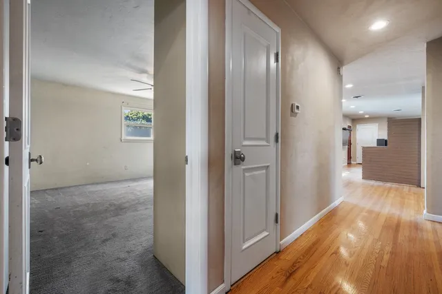 a view of a hallway with wooden floor