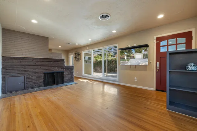 a view of an empty room with a fireplace and a window