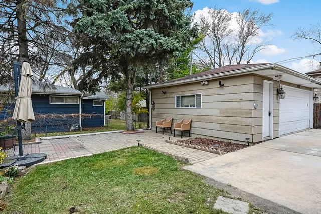 a view of a chair and table in backyard of the house