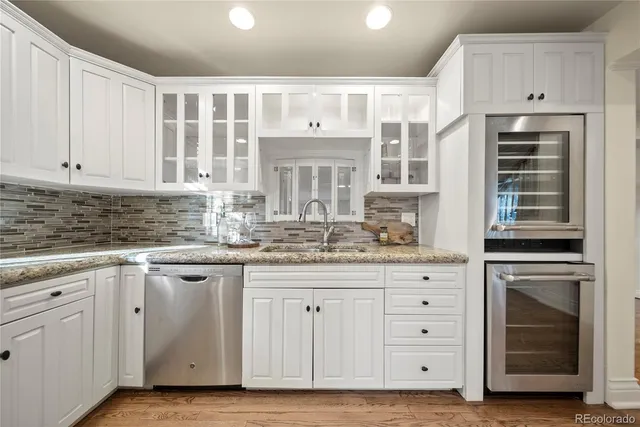 a kitchen with granite countertop white cabinets and stainless steel appliances
