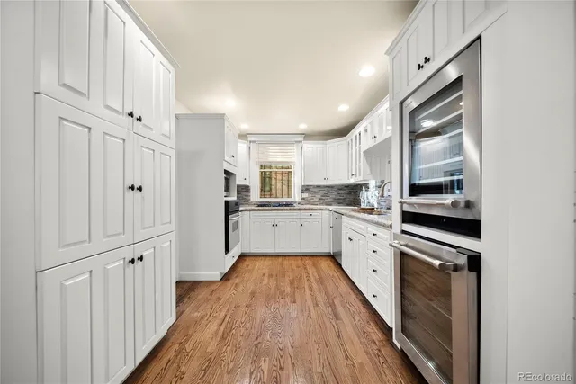 a kitchen with white cabinets and white appliances