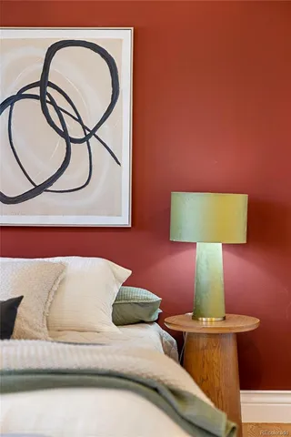 a bedroom with a bed and a lamp with the wooden floor