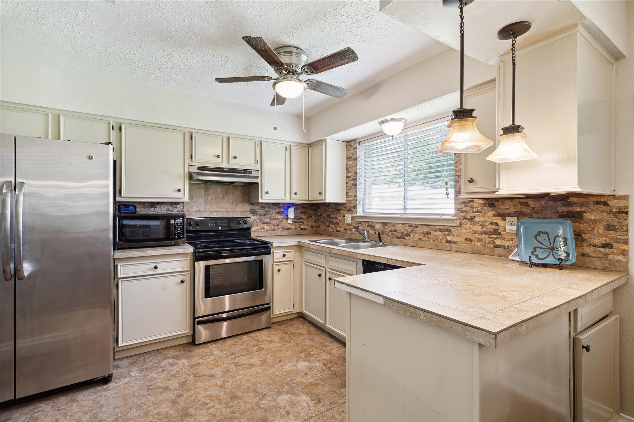 4226 Mossygate Drive Spring, TX 77373 - Photo 8 of 16 Kitchen (angle 1)
Galley-style kitchen with tile counters, stainless steel appliances, and under-cabinet lighting.