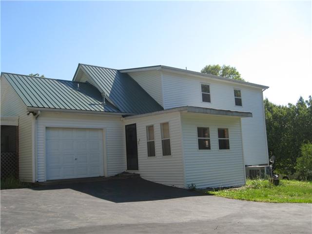 950 Woodhaven Road Lyles, TN 37098 - Photo 14 of 20 The rear view of the home. BIG and spacious. Shows the second story bedrooms. Enter the home off the Florida room(shown), The attached one car garage is also shown.( Includes an electric door opener). ...and the circular driveway.