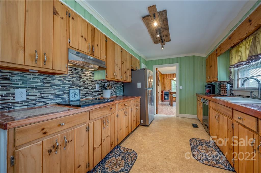 488 Elliott Road Rutherfordton, NC 28139 - Photo 14 of 44 a kitchen with stainless steel appliances granite countertop a sink a stove cabinets and a dining table