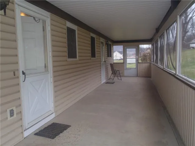 a view of a hallway with furniture and a window