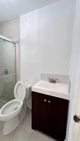 a white toilet sitting next to a bathroom sink and a mirror