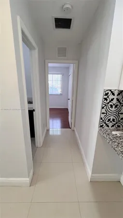 a view of a hallway to a bedroom with a fireplace