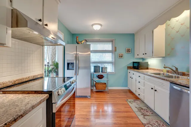 a kitchen that has a lot of cabinets in it and wooden floors