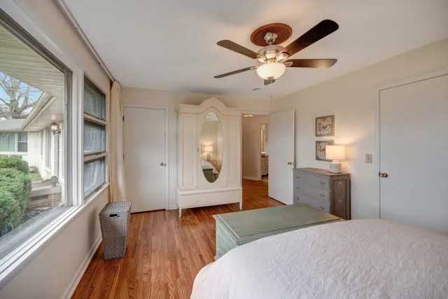 a bedroom with a large bed and wooden floor