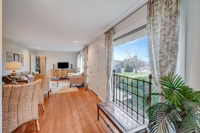 a living room with furniture a large window and a wooden floor