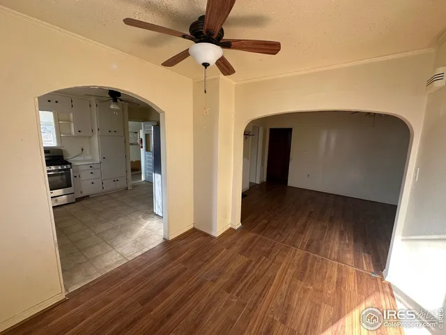 a view of a hallway with wooden floor and a cabinet