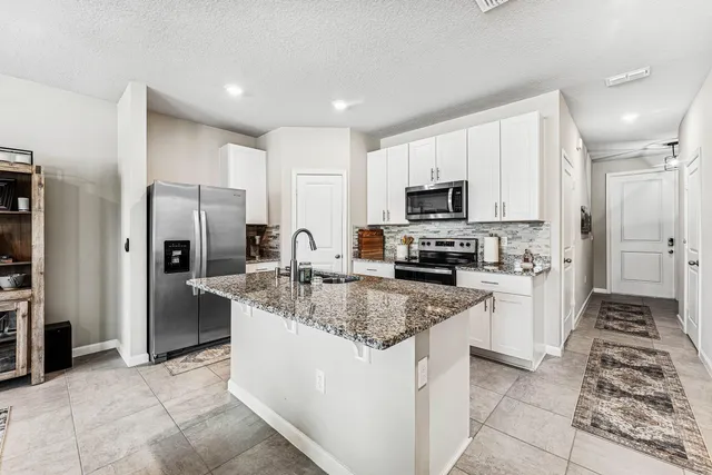 a kitchen with stainless steel appliances granite countertop a refrigerator stove and microwave