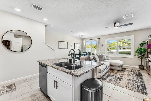 a kitchen with stainless steel appliances granite countertop a sink and a wooden floors