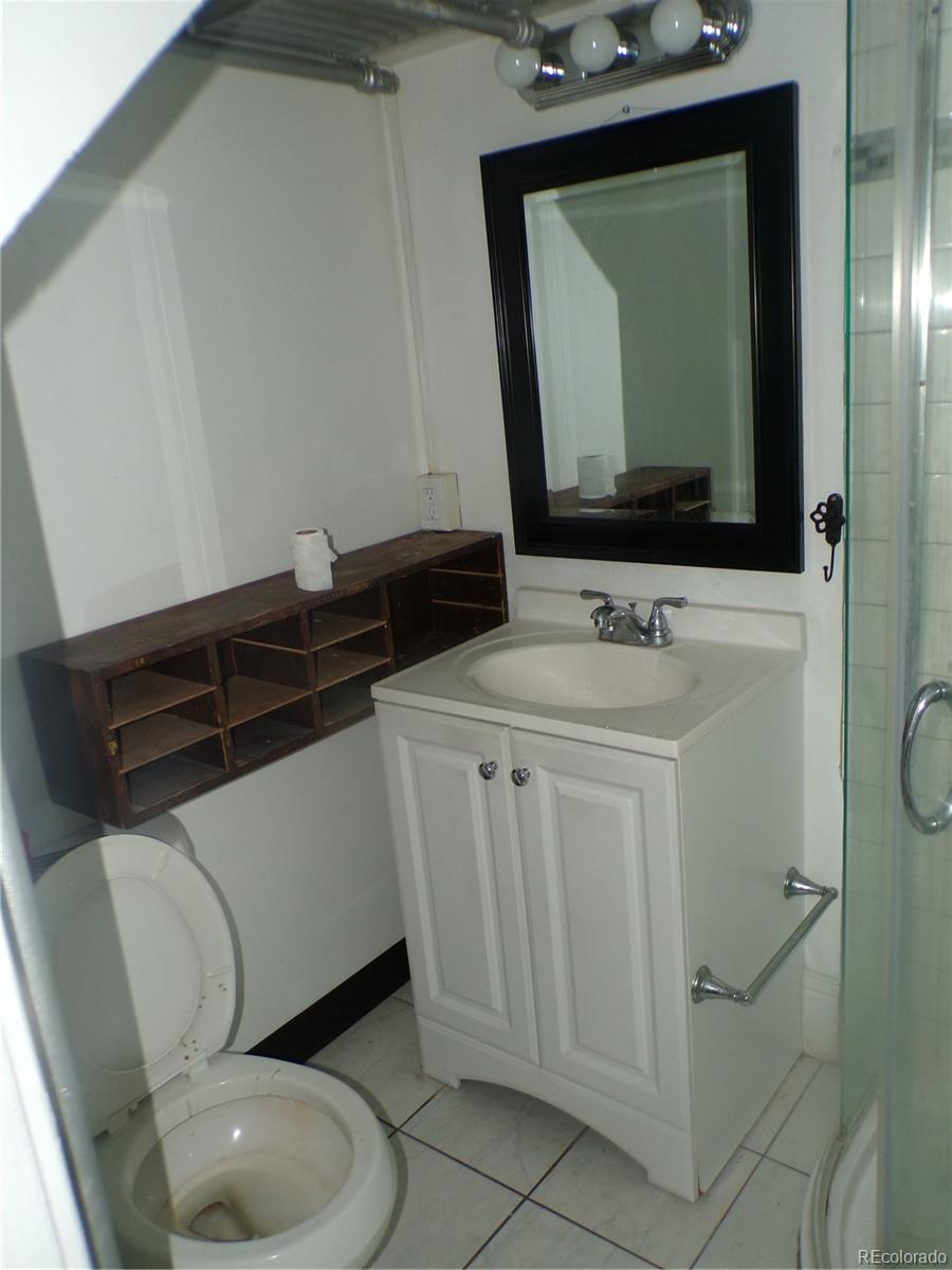 644 North Marion Street Denver, CO 80218 - Photo 8 of 19 a bathroom with a toilet sink and mirror