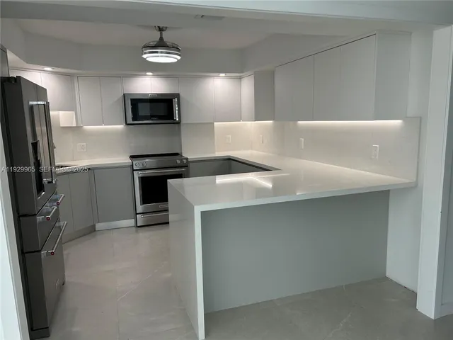 a kitchen with stainless steel appliances a refrigerator sink and microwave